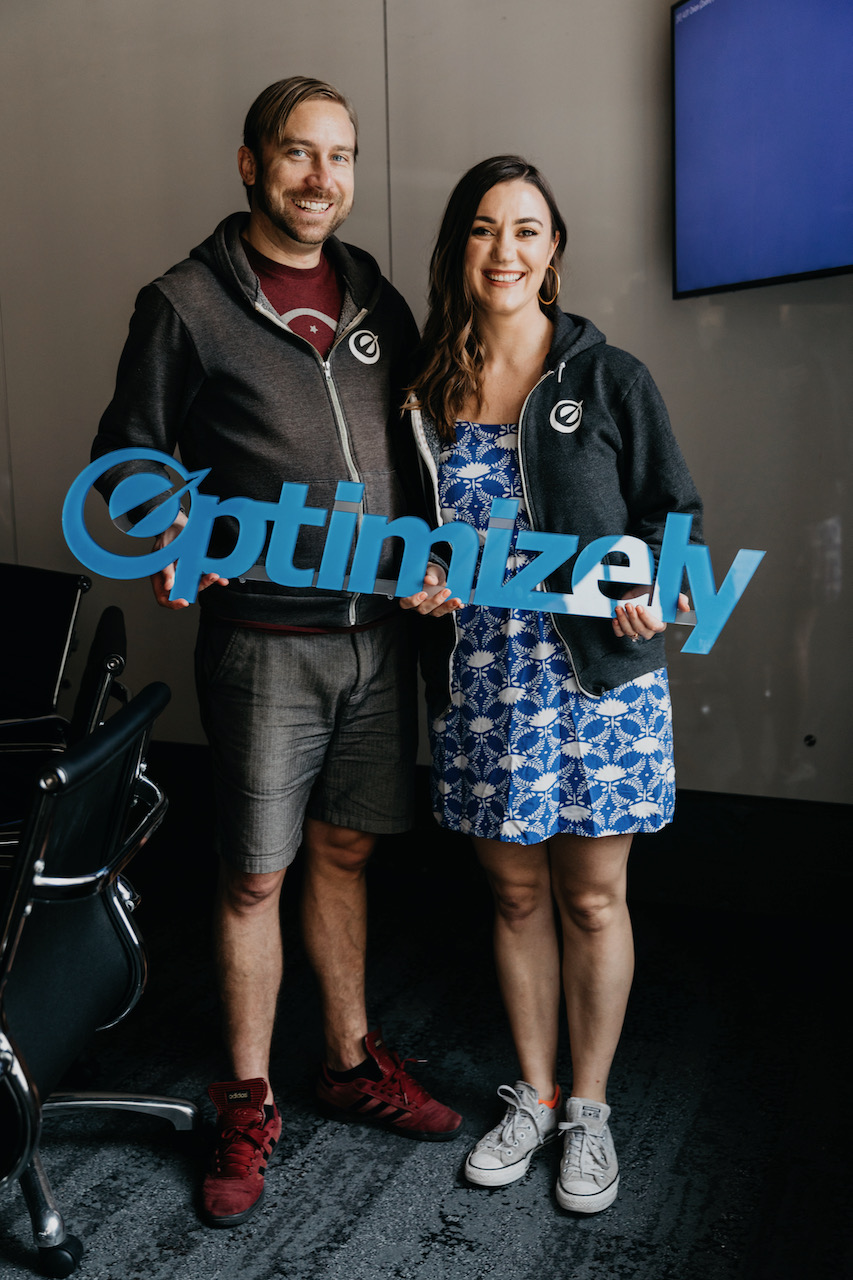 My wife and I, holding a sign of the original Optimizely logo